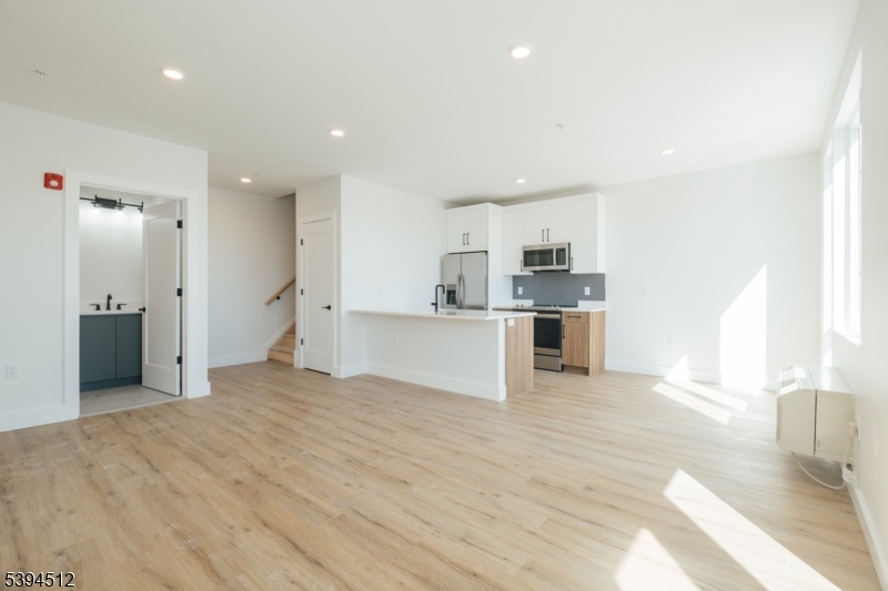 67 Dr Martin Luther King Jr Boulevard, Unit 204 Newark, NJ 07104 - Photo 3 of 27 a view of a kitchen with a sink and dishwasher a refrigerator with wooden floor