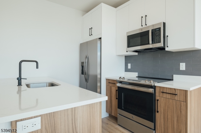 67 Dr Martin Luther King Jr Boulevard, Unit 204 Newark, NJ 07104 - Photo 4 of 27 a kitchen with a stove and a microwave