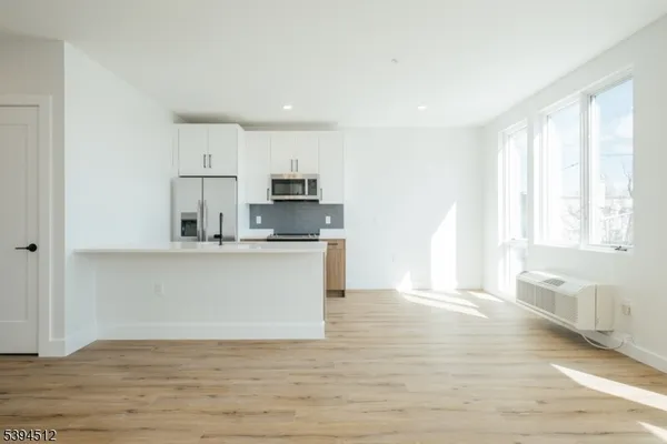 a view of kitchen with wooden floor and electronic appliances
