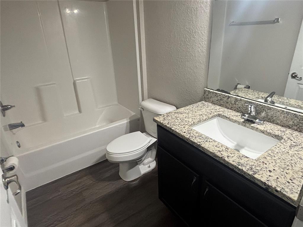 6561 Southwest 129th Loop Ocala, FL 34473 - Photo 16 of 21 a bathroom with a granite countertop sink toilet and shower