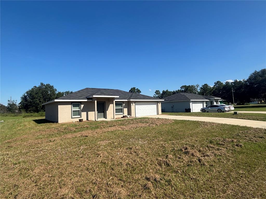 6561 Southwest 129th Loop Ocala, FL 34473 - Photo 2 of 21 a front view of a house with a yard