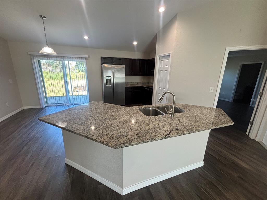 6561 Southwest 129th Loop Ocala, FL 34473 - Photo 5 of 21 a kitchen with stainless steel appliances granite countertop a sink dishwasher a stove and refrigerator with wooden floor