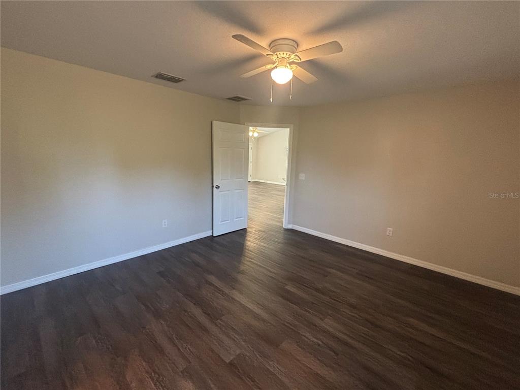 6561 Southwest 129th Loop Ocala, FL 34473 - Photo 9 of 21 an empty room with wooden floor and windows