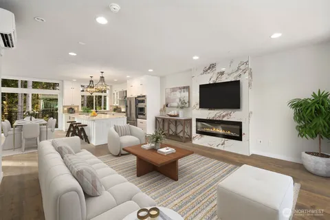 a living room with furniture a flat screen tv and kitchen view