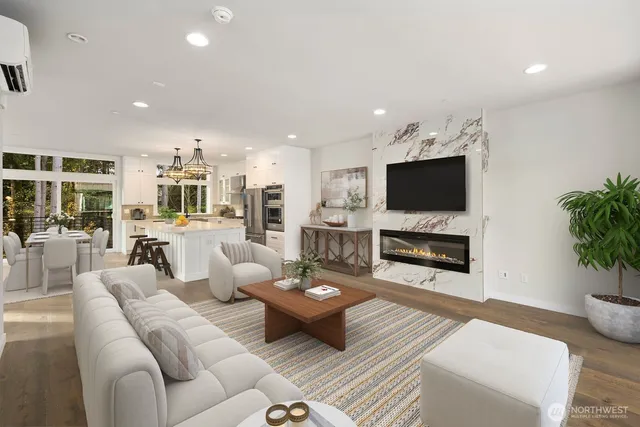 a living room with furniture a flat screen tv and kitchen view