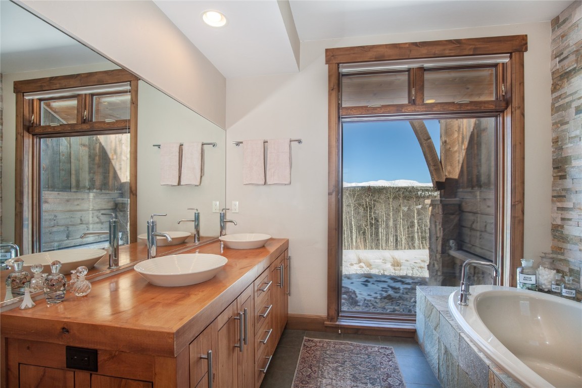 742 Lumberjack Road Fairplay, CO 80440 - Photo 19 of 35 a bathroom with a tub a sink and a large mirror
