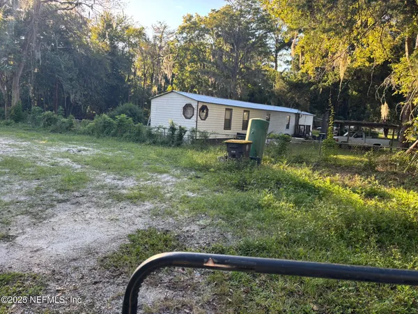a view of a small house with a yard