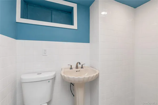 a bathroom with a sink a toilet and a mirror