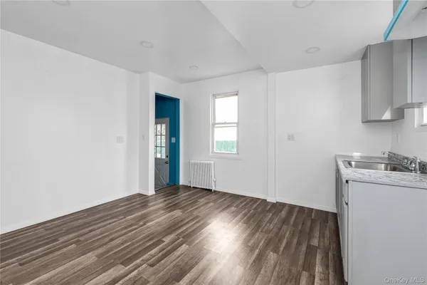 a view of a kitchen with wooden floor and a sink