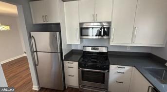 866 Bellevue Street Southeast, Unit 1 Washington, DC 20032 - Photo 3 of 9 a kitchen with stainless steel appliances a refrigerator a stove and white cabinets
