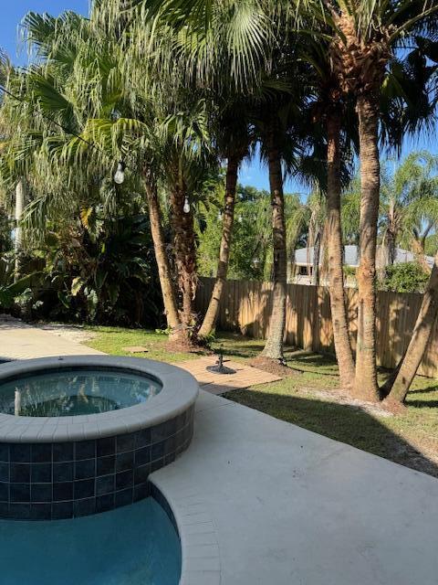 2420 Southeast Springtree Place Stuart, FL 34997 - Photo 17 of 18 a view of a swimming pool with a yard and palm trees