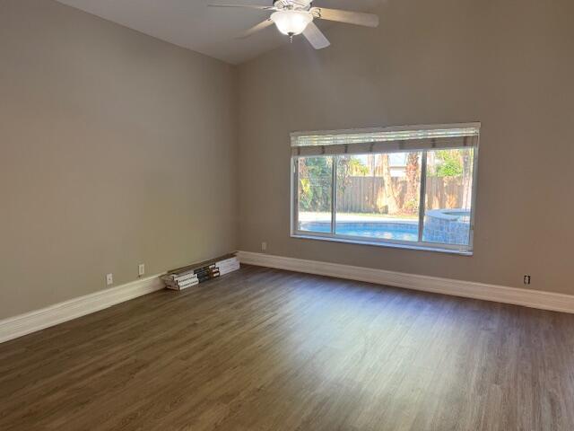 2420 Southeast Springtree Place Stuart, FL 34997 - Photo 10 of 18 a view of an empty room with wooden floor and a window