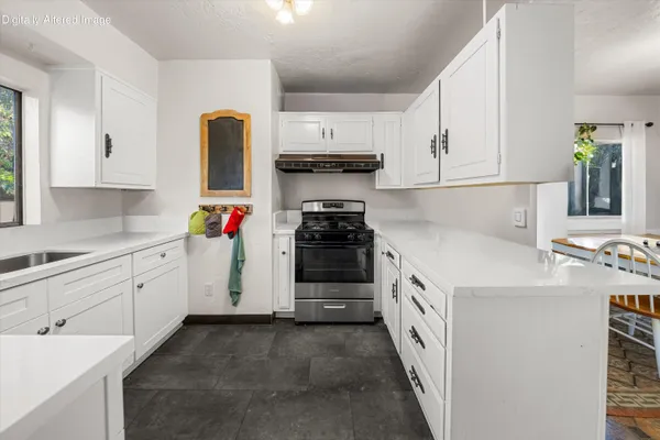 a kitchen with granite countertop white cabinets and white appliances