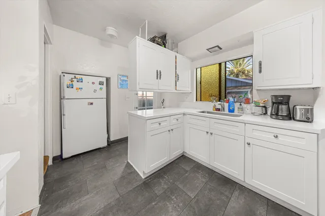 a kitchen with white cabinets and white appliances