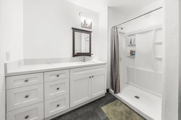 a bathroom with a shower sink and mirror