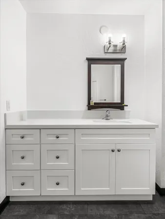 a bathroom with a sink vanity and mirror