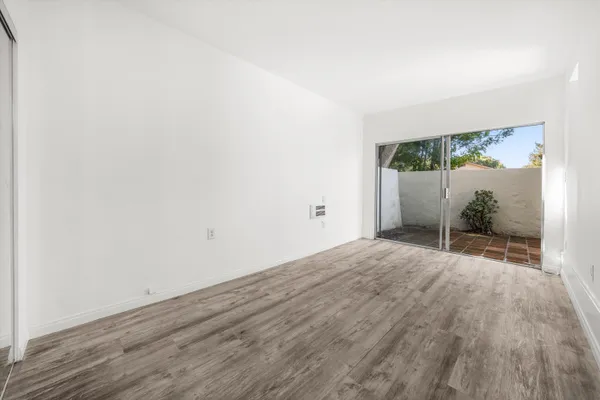 a view of a room with wooden floor and a potted plant