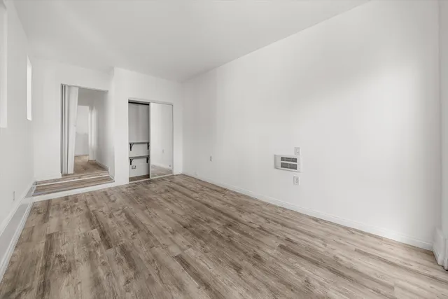 a view of empty room with wooden floor