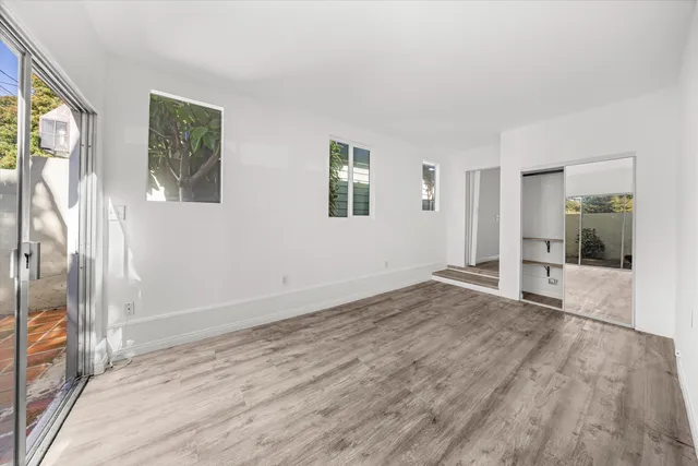 a view of empty room with wooden floor