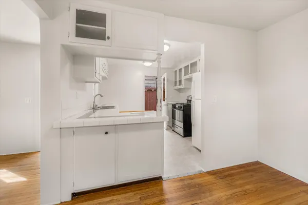 a kitchen with granite countertop a sink stove and cabinets