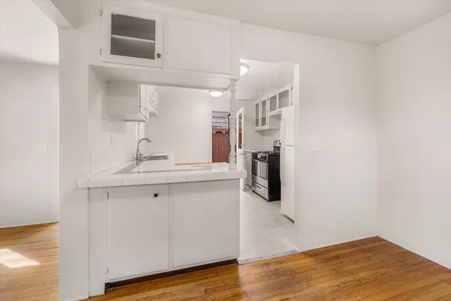 a kitchen with granite countertop a sink stove and cabinets