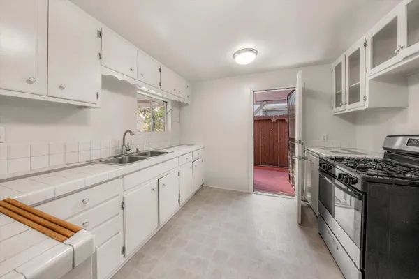 a kitchen with white cabinets and white appliances
