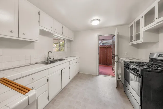 a kitchen with white cabinets and white appliances