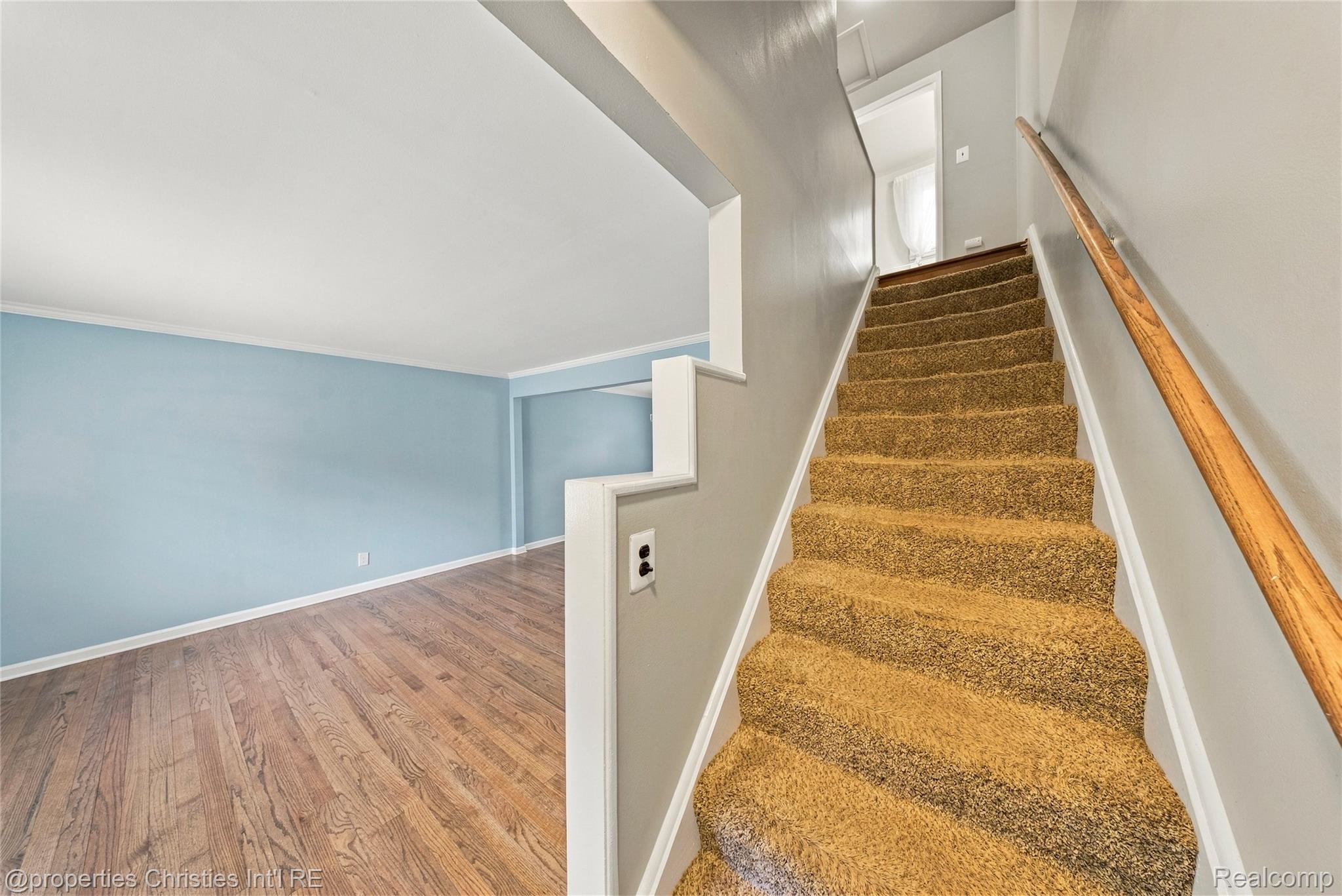 1642 Graefield Road, Unit 75 Birmingham, MI 48009 - Photo 11 of 25 Wood-finish flooring, staircase with carpeted treads, and a wooden handrail