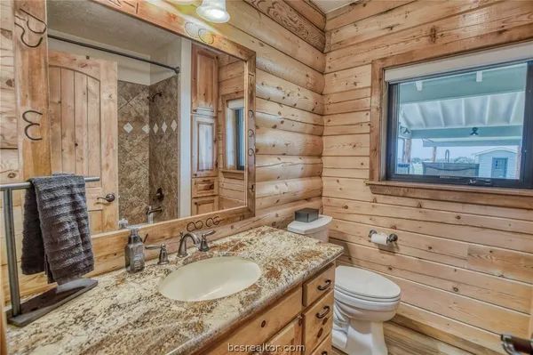 a bathroom with a granite countertop sink toilet and shower