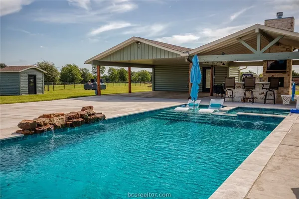 a view of a house with a swimming pool and sitting area