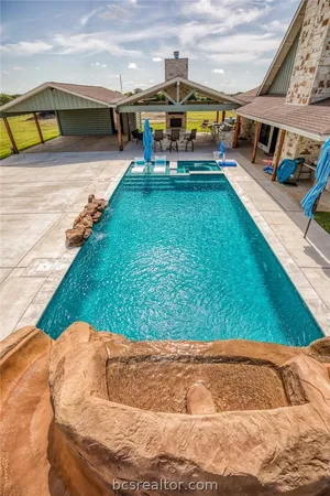 a view of a backyard with swimming pool