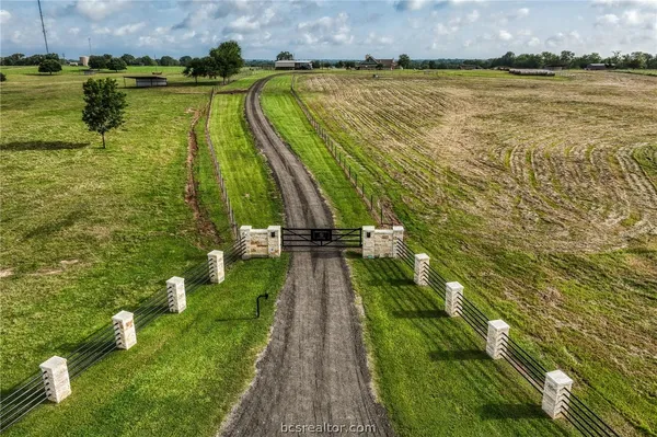 a view of a house with a big yard and large trees