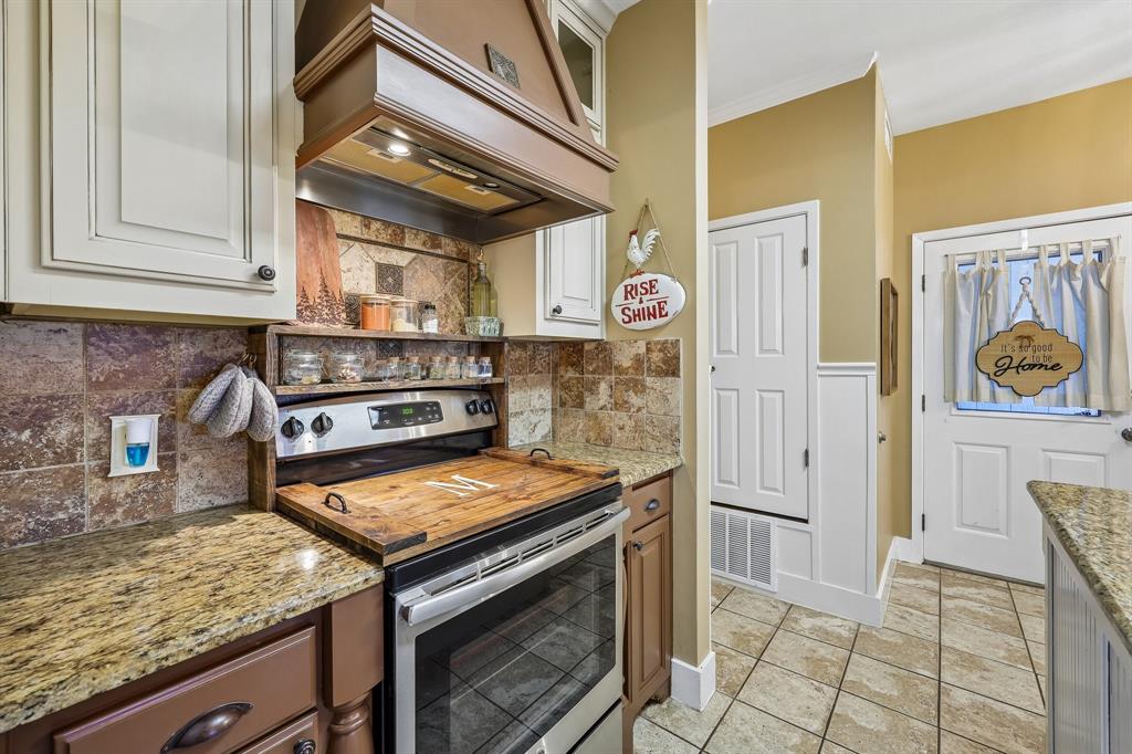 331 Radecke Road Krum, TX 76249 - Photo 16 of 40 Kitchen featuring a stainless steel range with a custom wood vent hood, granite countertops, and tile backsplash
