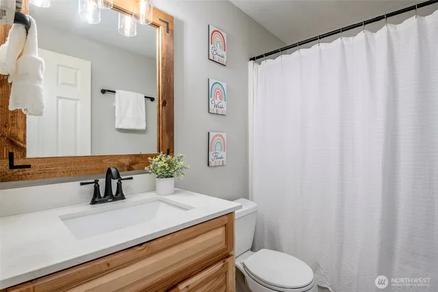 a bathroom with a sink a toilet and a mirror