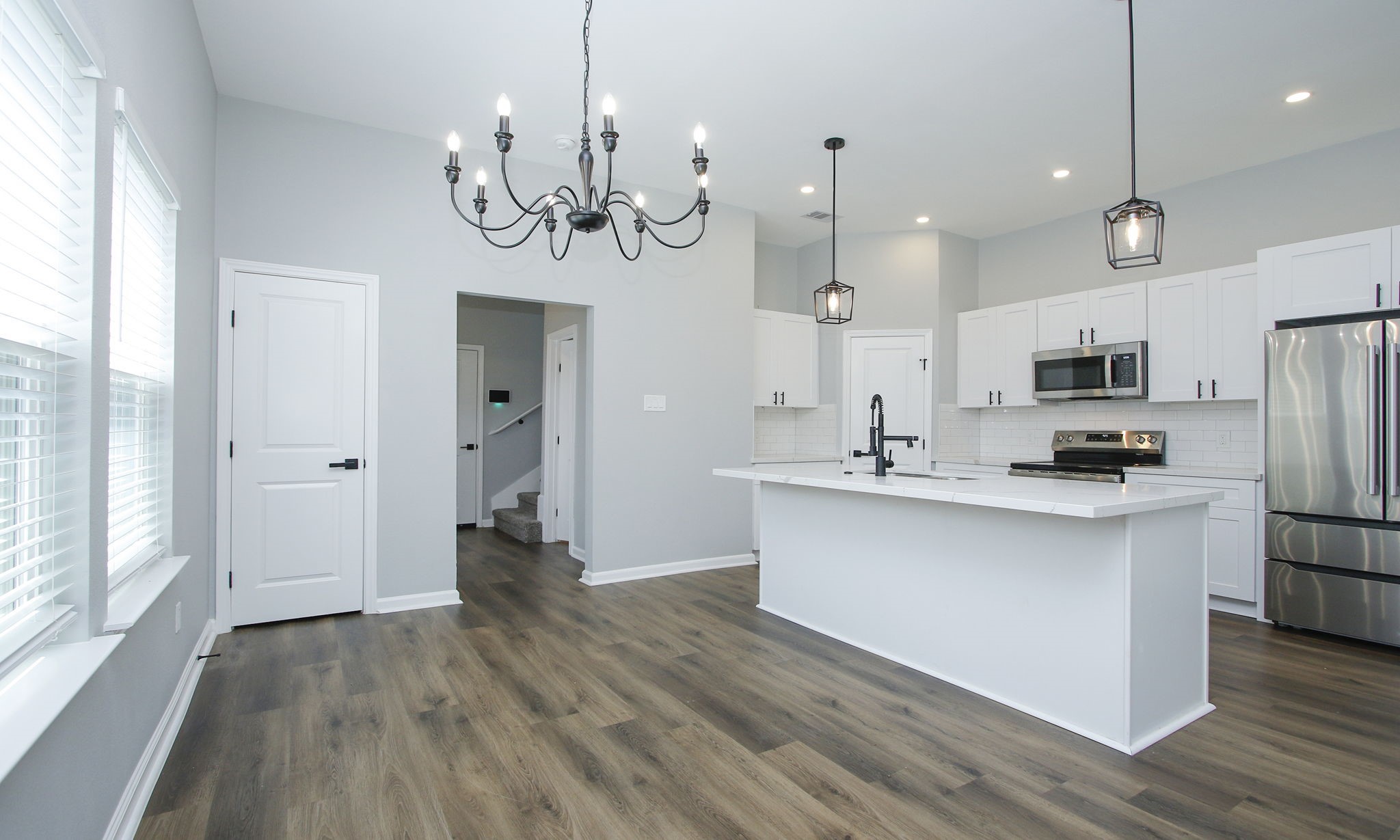 a kitchen with stainless steel appliances granite countertop a refrigerator a sink dishwasher a kitchen island with wooden floor and cabinets