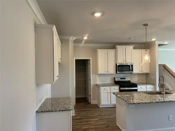 a kitchen with stainless steel appliances granite countertop a stove a sink and a refrigerator