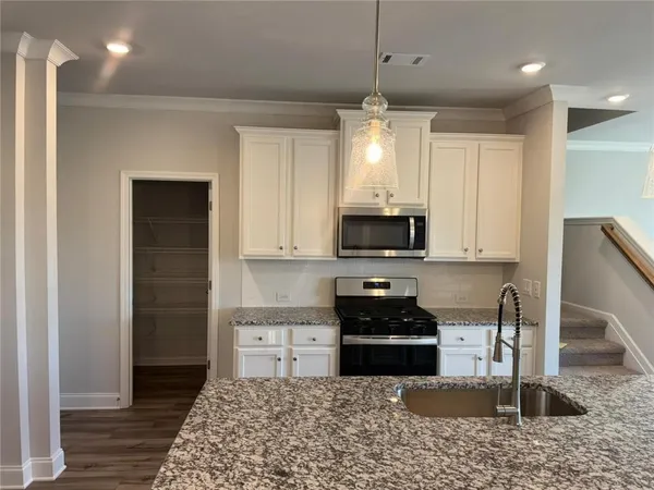 a kitchen with stainless steel appliances granite countertop a stove a sink and a refrigerator