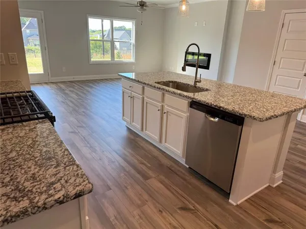 a kitchen with sink wooden floor and window