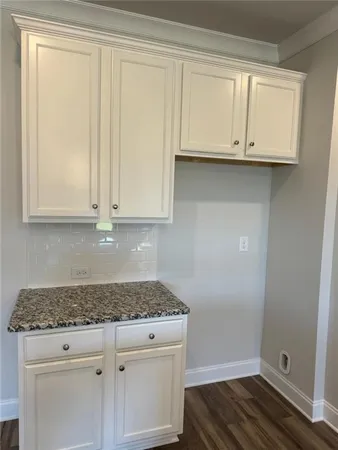 a kitchen with granite countertop white cabinets and sink