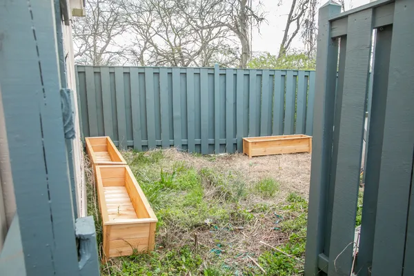 a view of backyard with wooden fence
