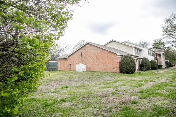 a view of a white house with a large windows and plants