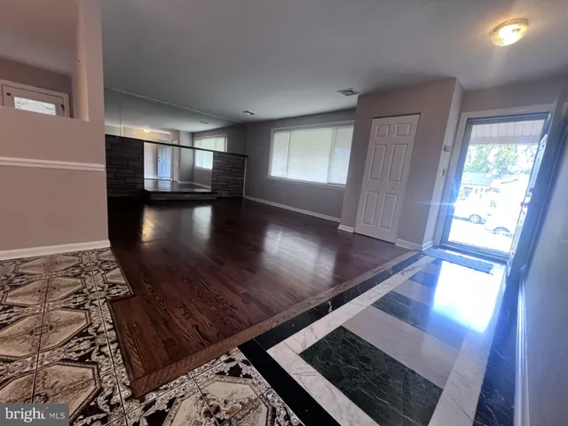 a view of a room with lots of wooden furniture and a chandelier