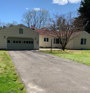 a view of house with yard and trees in the background
