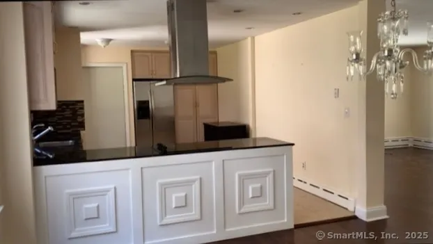 a kitchen with white cabinets and refrigerator