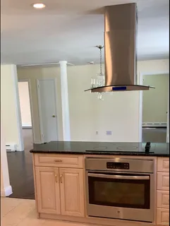 a kitchen with granite countertop white cabinets and black appliances