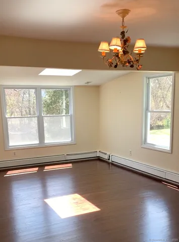 a view of a livingroom with wooden floor and a large window