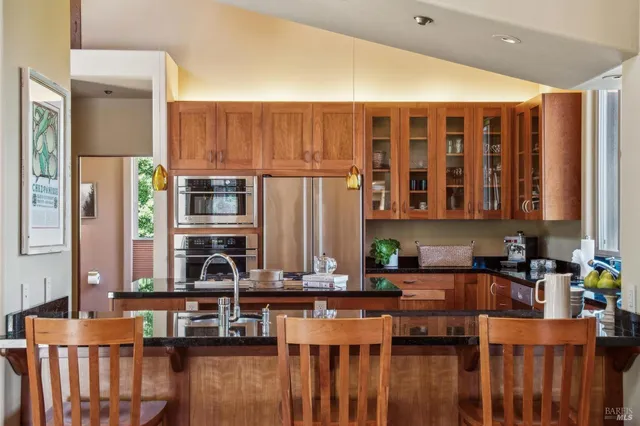 a kitchen that has a lot of cabinets in it and wooden floor