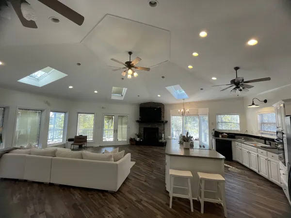 a living room with furniture kitchen view and a wooden floor