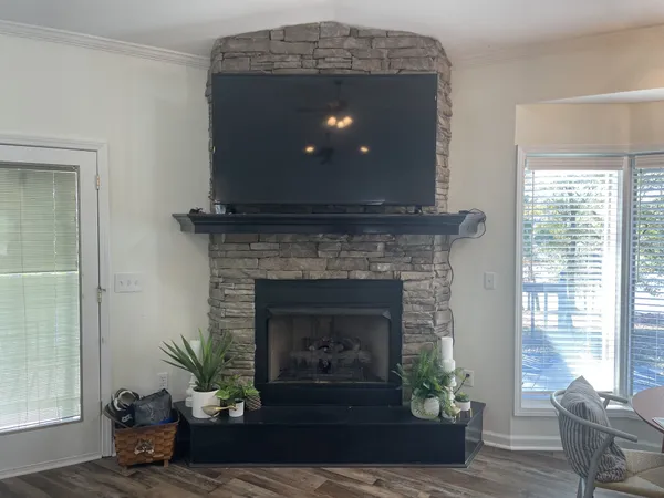 a living room with a fireplace and wooden floor