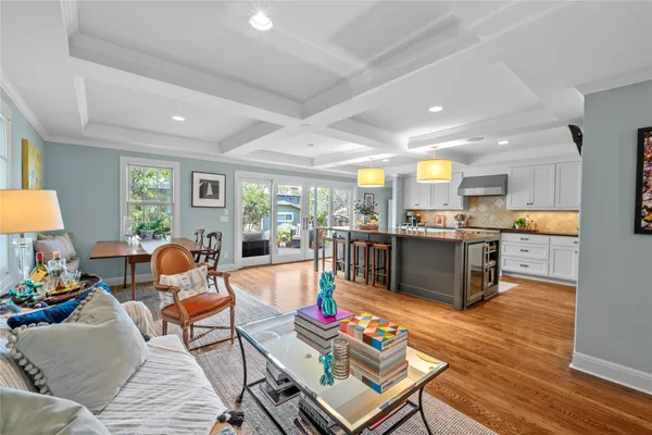 a living room filled with lots of furniture and kitchen view